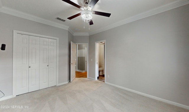 unfurnished bedroom with a closet, light colored carpet, ceiling fan, and crown molding