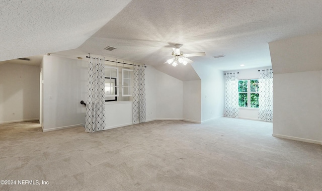 bonus room with a textured ceiling, ceiling fan, light colored carpet, and vaulted ceiling