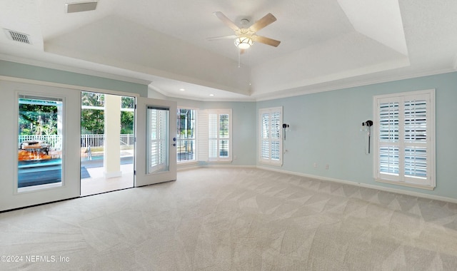 carpeted spare room featuring ceiling fan, french doors, crown molding, and a tray ceiling