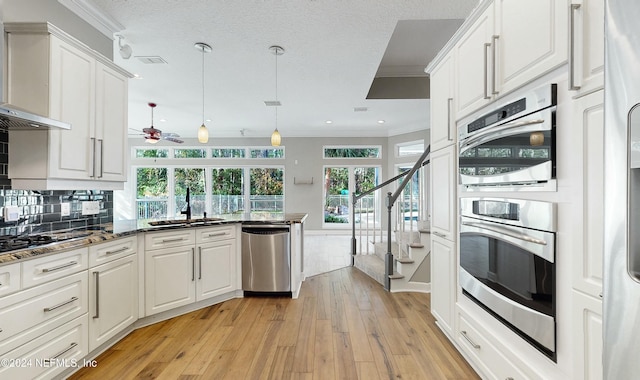 kitchen featuring appliances with stainless steel finishes, white cabinetry, ceiling fan, and sink