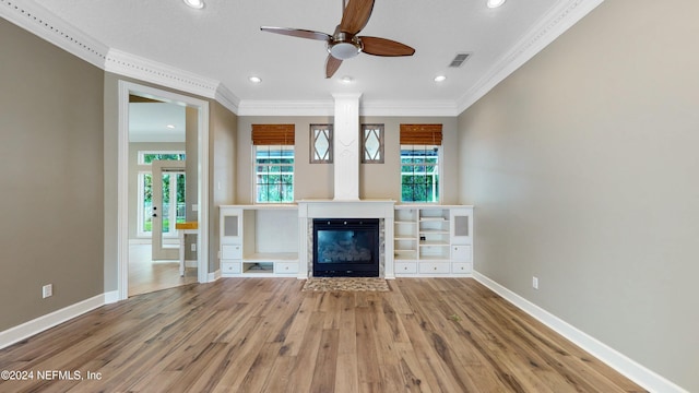 unfurnished living room with hardwood / wood-style floors, ceiling fan, and crown molding