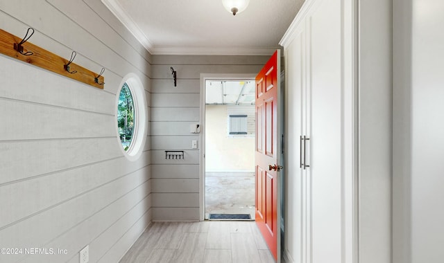 hall featuring wooden walls and crown molding