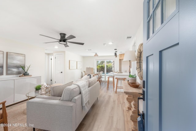 living room featuring ceiling fan and light wood-type flooring