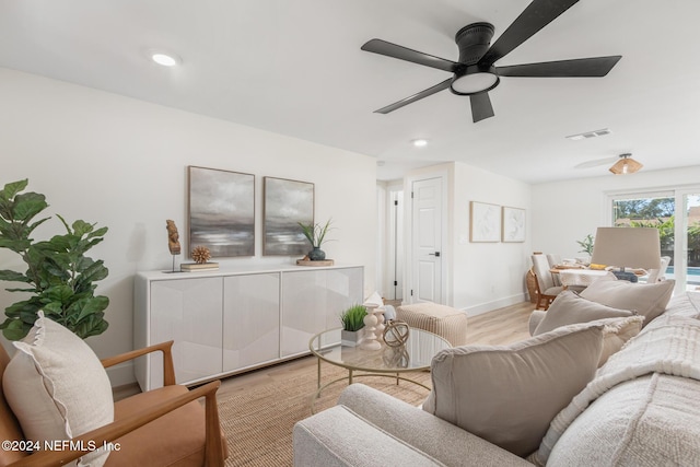 living room featuring light hardwood / wood-style floors and ceiling fan