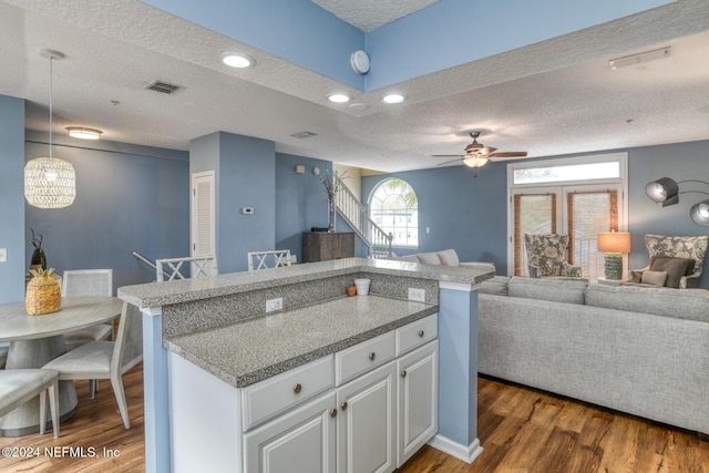 kitchen with white cabinetry, ceiling fan, dark hardwood / wood-style floors, pendant lighting, and a textured ceiling