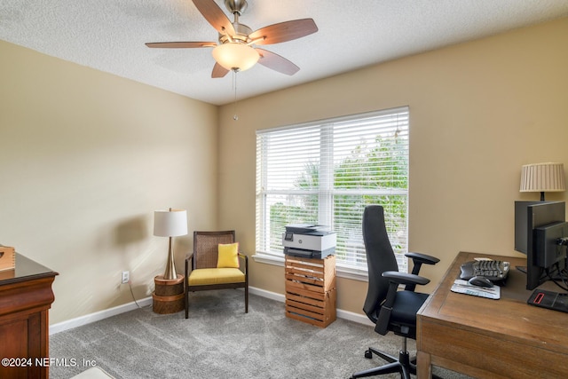 home office featuring carpet flooring, ceiling fan, and a textured ceiling