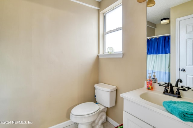 bathroom featuring a textured ceiling, vanity, and toilet