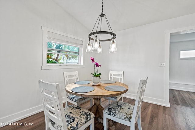 dining area with dark hardwood / wood-style floors, a healthy amount of sunlight, and vaulted ceiling