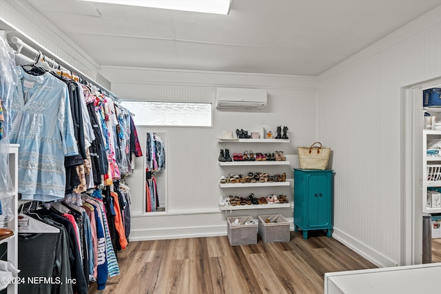 walk in closet featuring hardwood / wood-style flooring and a wall mounted AC