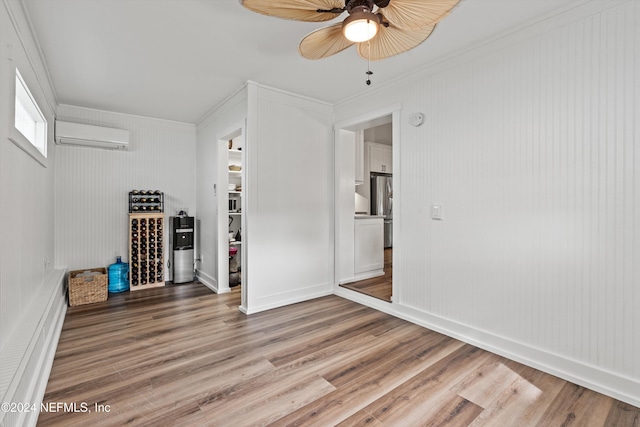 unfurnished room with wood-type flooring, a wall mounted AC, ornamental molding, and ceiling fan