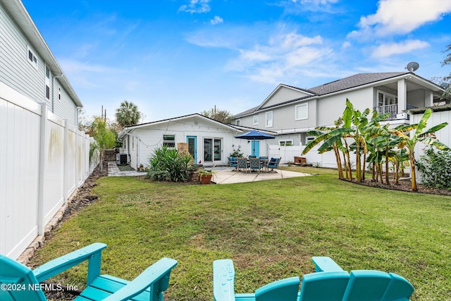 back of property with a patio area and a lawn