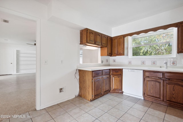 kitchen featuring sink, light tile patterned floors, white dishwasher, ceiling fan, and backsplash