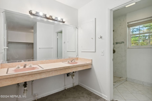 bathroom with double sink and tiled shower