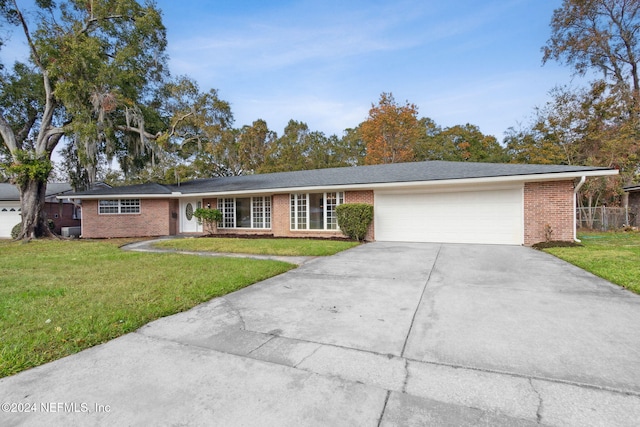 ranch-style home with a garage and a front lawn