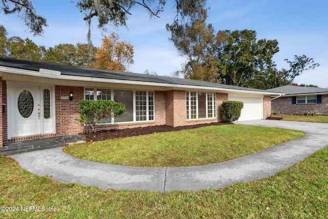 ranch-style home with a garage and a front lawn