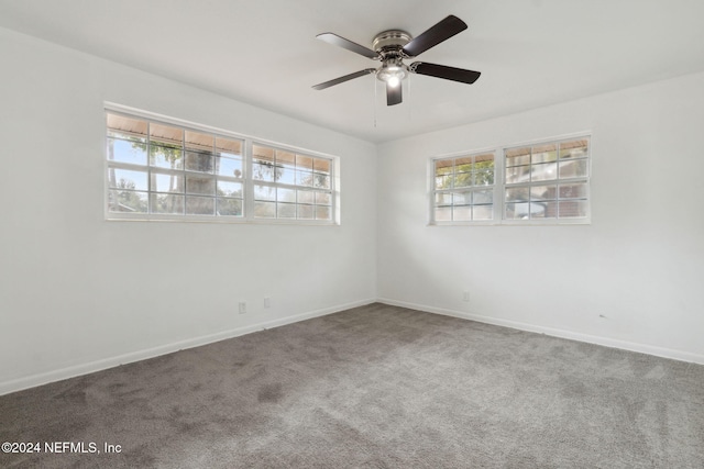 carpeted spare room featuring ceiling fan