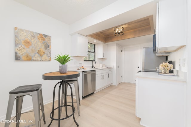 kitchen with dishwasher, sink, a tray ceiling, light hardwood / wood-style floors, and white cabinetry