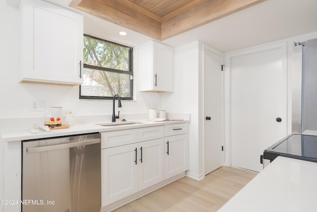 kitchen featuring stainless steel dishwasher, white cabinets, and sink