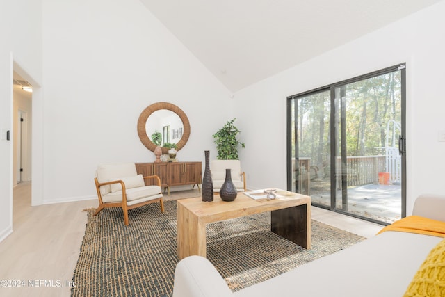 sitting room with light hardwood / wood-style flooring and high vaulted ceiling