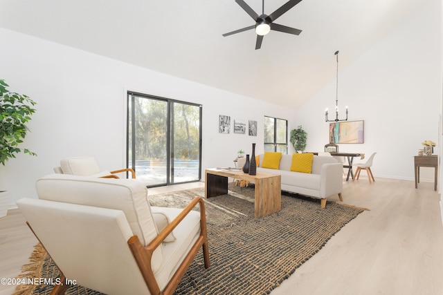 living room featuring ceiling fan with notable chandelier, high vaulted ceiling, and light hardwood / wood-style flooring