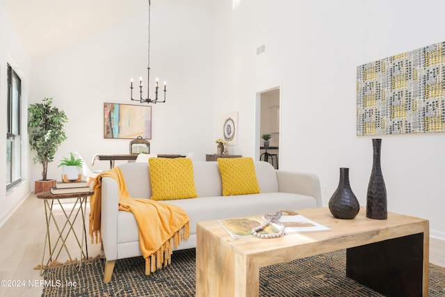 living room with an inviting chandelier, hardwood / wood-style flooring, and high vaulted ceiling