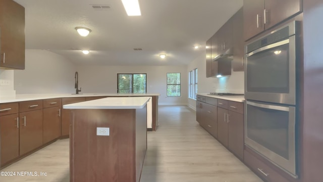 kitchen featuring a center island, gas stovetop, sink, and light hardwood / wood-style flooring