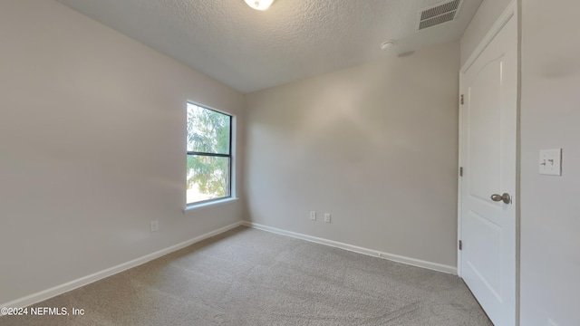 carpeted spare room with a textured ceiling