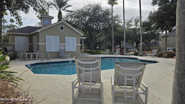 view of swimming pool featuring a patio area and grilling area