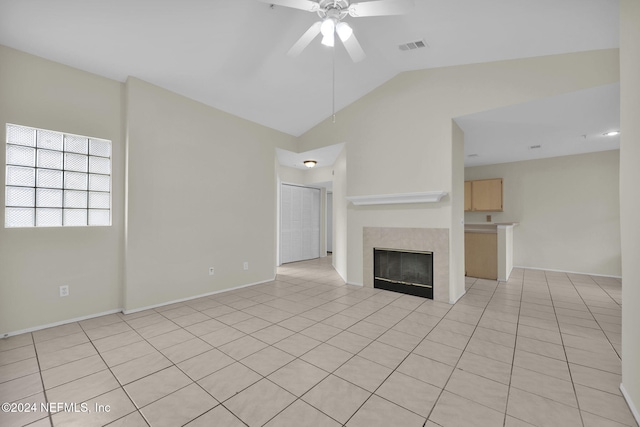 unfurnished living room with ceiling fan, light tile patterned flooring, a tiled fireplace, and lofted ceiling