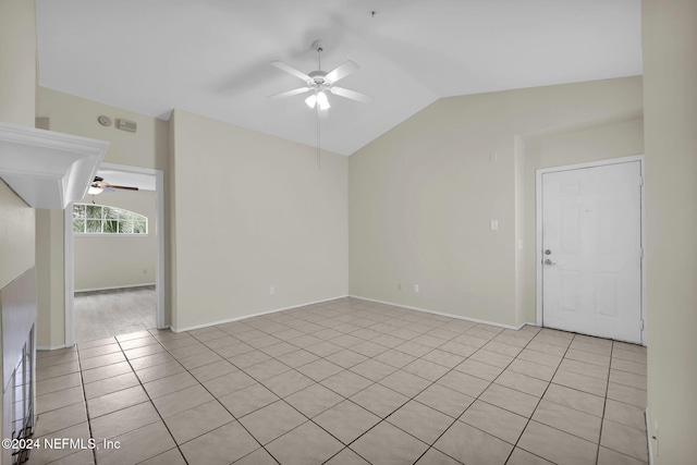 tiled empty room with vaulted ceiling and ceiling fan