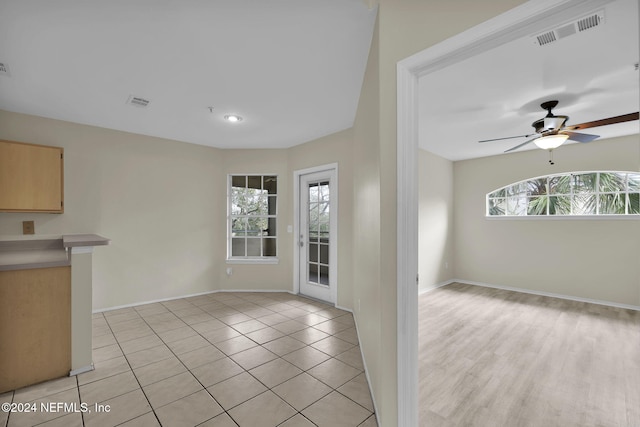 foyer with ceiling fan, light tile patterned flooring, and a healthy amount of sunlight