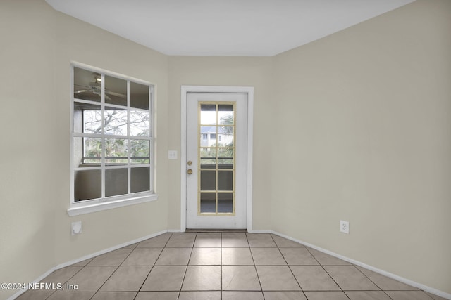 doorway to outside with light tile patterned flooring