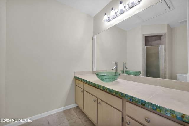 bathroom featuring a shower with door, tile patterned floors, vanity, and toilet