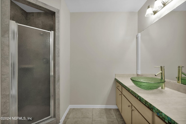 bathroom featuring vanity, a shower with shower door, and tile patterned flooring