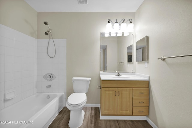 full bathroom featuring tiled shower / bath combo, hardwood / wood-style flooring, toilet, and vanity