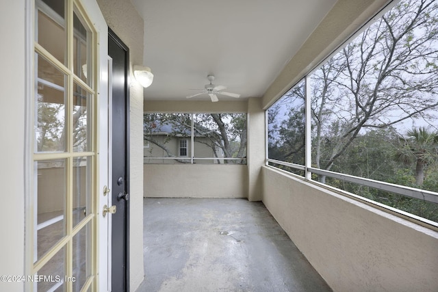 unfurnished sunroom featuring a healthy amount of sunlight and ceiling fan