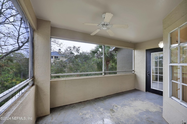 unfurnished sunroom with ceiling fan