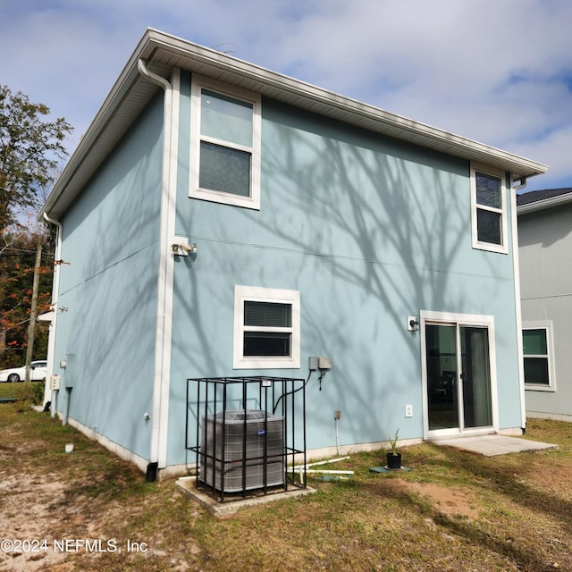 back of house with a yard and central air condition unit