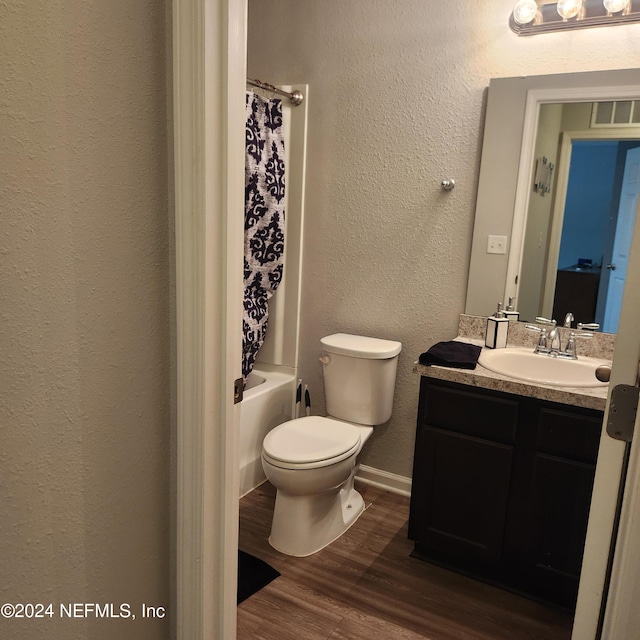 full bathroom featuring hardwood / wood-style flooring, vanity, toilet, and shower / bath combo with shower curtain