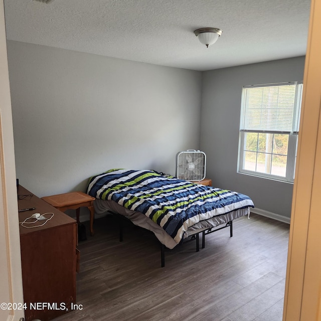 bedroom with hardwood / wood-style flooring and a textured ceiling