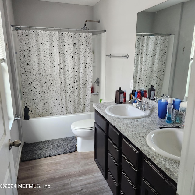 full bathroom featuring shower / bathtub combination with curtain, toilet, vanity, and hardwood / wood-style flooring