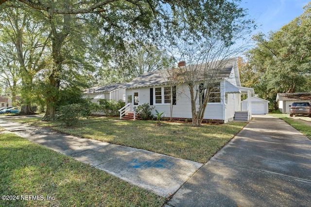 ranch-style house with a garage, an outdoor structure, and a front yard