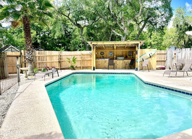 view of pool featuring a bar and a patio