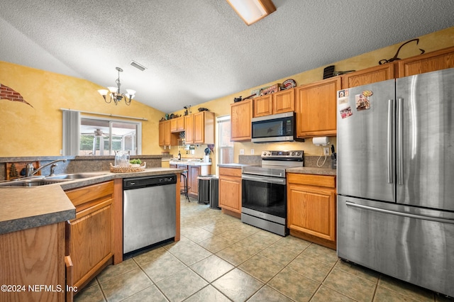 kitchen with lofted ceiling, an inviting chandelier, sink, decorative light fixtures, and stainless steel appliances