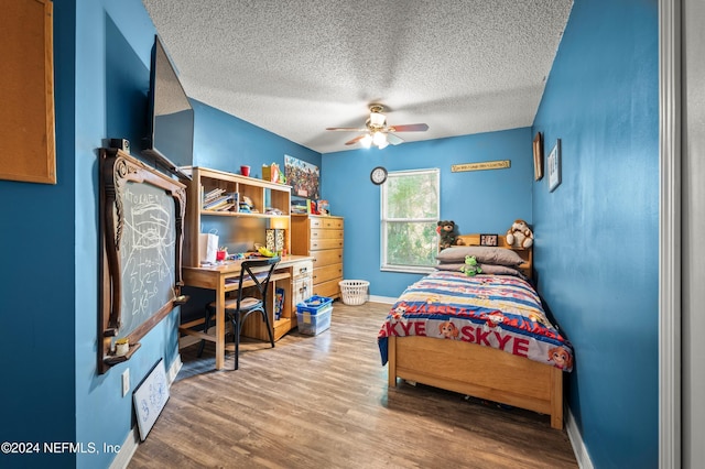 bedroom featuring ceiling fan, a textured ceiling, and hardwood / wood-style flooring