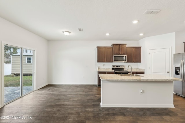 kitchen with sink, dark wood-type flooring, stainless steel appliances, and an island with sink