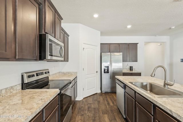 kitchen with dark brown cabinets, a textured ceiling, stainless steel appliances, sink, and dark hardwood / wood-style floors