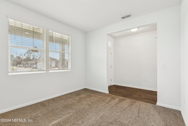 empty room with dark colored carpet