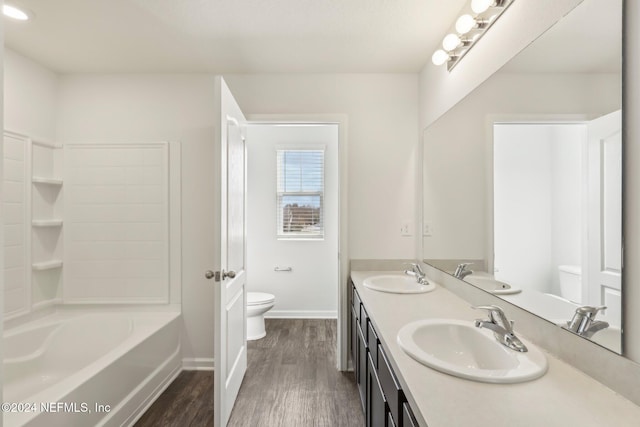 full bathroom featuring hardwood / wood-style floors, vanity, toilet, and shower / bath combination