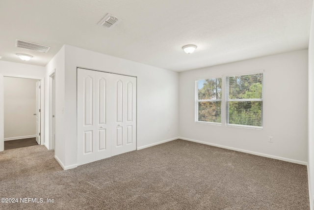 unfurnished bedroom with carpet flooring and a closet